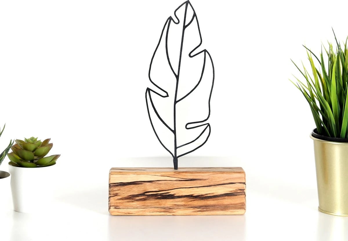 Objekt dekorativ, formë pendë, metal i zi, bazë druri, 17x30x3.5cm